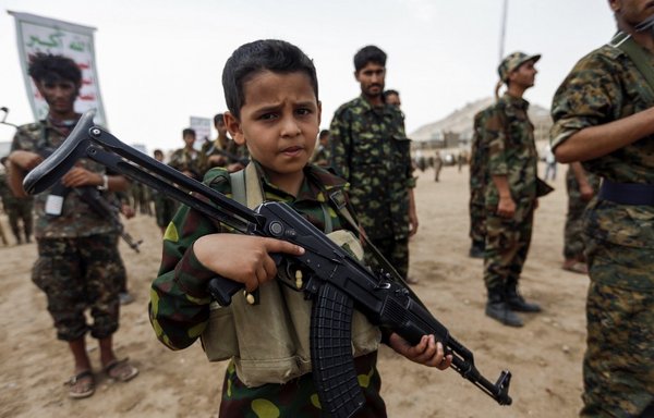 A Yemeni boy poses with a Kalashnikov assault rifle during a gathering of newly-recruited Houthi fighters in the capital Sanaa, to mobilise more fighters to the battlefronts in the war against pro-government forces in several Yemeni cities, on July 16th, 2017. [Mohammed Huwais/FP]