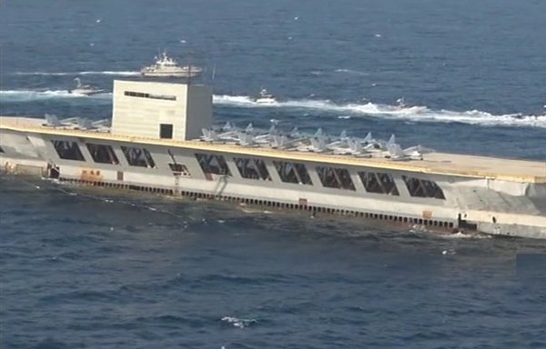 نیروهای ایرانی، طی یک رزمایش اخیر، که به صورت گسترده‌ای یک اقدام تحریک‌آمیز تلقی شده است، ماکت یک ناو هواپیمابر آمریکایی را با چند موشک هدف قرار دادند. [تصویر برگرفته از یک ویدئوی فارس نیوز]
