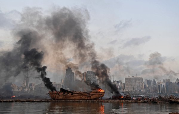 تظهر هذه الصورة سفينة محترقة في مرفأ بيروت عقب الانفجار الهائل الذي ضرب قلب العاصمة اللبنانية يوم 4 آب/أغسطس. [وكالة الصحافة الفرنسية]