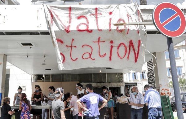 Des volontaires, vêtus de masques en raison de la pandémie du coronavirus, distribuent des repas aux personnes touchées par l'explosion du port de Beyrouth dans le quartier d'Achrafieh de la ville lundi 10 août. [Anwar Amro / AFP]