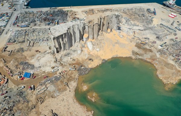 An aerial view taken August 9th, shows a general view of the port of Beirut, the damaged grain silo and the crater caused by the colossal explosion of a huge pile of ammonium nitrate that had languished for years in a port warehouse. The blast left a 43-metre deep crater. [AFP]