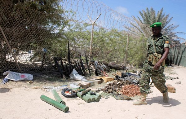 Un soldat de la force AMISOM de l'Union africaine passe devant des armes saisies suite à de violents affrontements dans la matinée du 15 août 2014 à Mogadiscio, où les troupes de l'Union africaine sont intervenues en soutien aux forces gouvernementales dans la bataille pour prendre ces armes à une milice locale. [Abdulfitah Hashi Nor/AFP]