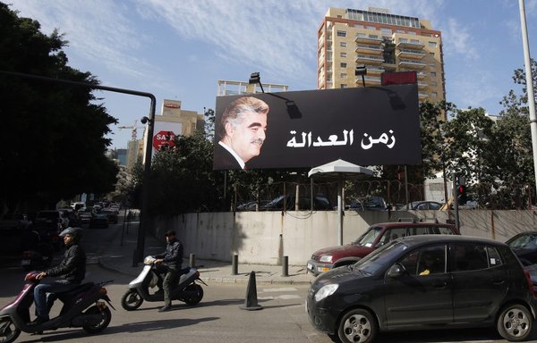 Un panneau d'affichage arborant le portrait du Premier ministre libanais décédé Rafiq al-Hariri sur un axe majeur de Beyrouth le 16 janvier 2014, alors que quatre membres du Hezbollah étaient jugés par contumace par un tribunal soutenu par les Nations unies aux Pays-Bas, accusés d'avoir assassiné al-Hariri dans un attentat à la voiture piégée en 2005. Le tribunal a rendu son verdict le 18 août 2020. [Anwar Amro/AFP]