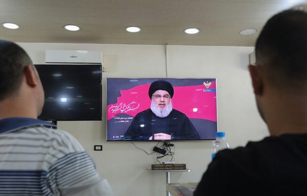 Lebanese men watch Hizbullah chief Hassan Nasrallah during a televised speech, at a coffee shop in the southern suburbs of Beirut, on August 30th. [Anwar Amro/AFP]