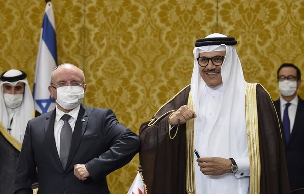 مستشار الأمن القومي الإسرائيلي مئير بن شبات يصافح بمرفقه وزير الخارجية البحريني عبد اللطيف بن راشد الزياني بعد حفل التوقيع في المنامة يوم 18 تشرين الأول/أكتوبر، فيما ينظر وزير الخزانة الأميركي ستيف منوتشين إليهما. [مازن مهدي / وكالة الصحافة الفرنسية]