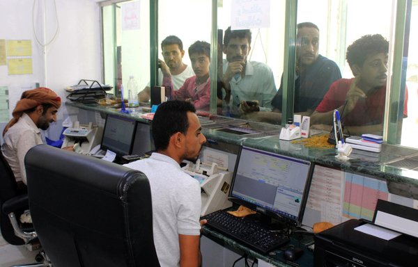 مردان یمنی منتظر در یک صرافی در ۳ بهمن در شهر بندری عدن در جنوب. [صالح العبیدی/ خبرگزاری فرانسه]
