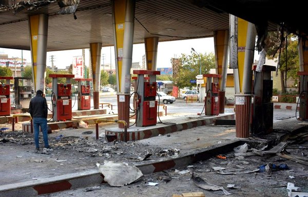 Dans cette photo d'archive prise le 17 novembre 2019, un homme iranien examine une station d'essence incendiée pendant une manifestation suite à la hausse des prix de l'essence à Eslamshahr, près de Téhéran. Un an après la répression implacable des manifestations par les autorités iraniennes, le chagrin sur des centaines de vies perdues est accompagné de colère face à l'absence d'imputabilité pour une répression dont l'ampleur commence à peine à émerger. [AFP]