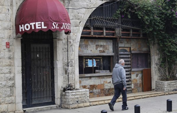Un homme passe le 1er décembre devant un hôtel fermé dans le principal marché commercial de Jounieh. [Joseph Eid/AFP]