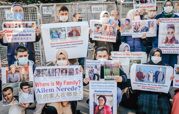 Members of the Muslim Uighur minority hold placards as they demonstrate in front of the Chinese consulate on December 30 in Istanbul, to ask for news of their relatives missing or incarcerated in Xinjiang. [Bulent Kilic/AFP]