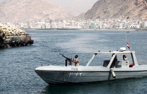 A picture taken on August 8, 2018, shows a Yemeni military patrol boat cruising past the docks in the Hadramaut provincial capital of al-Mukalla. [Karim Sahib/AFP]
