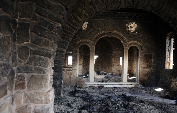 A picture shows the interior of a burnt church at the monastery of Syriac Catholic Saint Elian, who lived in the fifth century AD, in al-Qaryatain, one of the last ISIS strongholds in central Syria, on April 4, 2016 -- a day after Syrian regime forces regained control of the town. [Joseph Eid/AFP]