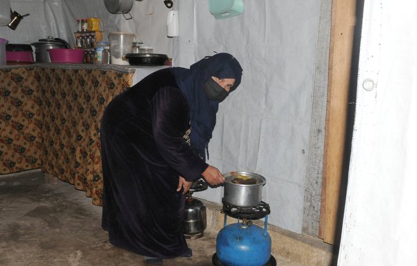 Syrian refugee Shama al-Hadid prepares an iftar meal consisting of mainly grains and vegetables this year. Al-Hadid is wistful over the absence of meat from their meals due to its high prices. [Ziad Hatem/Al-Mashareq]