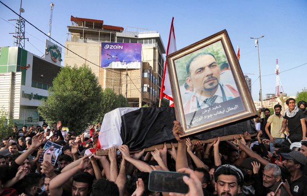 People chant anti-Iran slogans as they march with the coffin of renowned Iraqi activist Ihab al-Wazni during a funeral procession in Karbala on May 9, following his assassination. [Mohammed Sawaf/AFP]