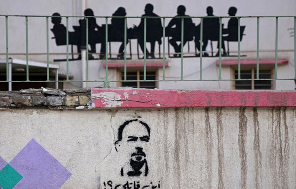 صورة التقطت في 23 أيار/مايو تظهر رسوما على الجدران كُتب فيها "أين قاتلي؟" وتعرض صورة للناشط العراقي البارز إيهاب الوزني الذي قُتل بالرصاص في كمين في وقت سابق من الشهر الجاري في كربلاء. [محمد الصواف/وكالة الصحافة الفرنسية]