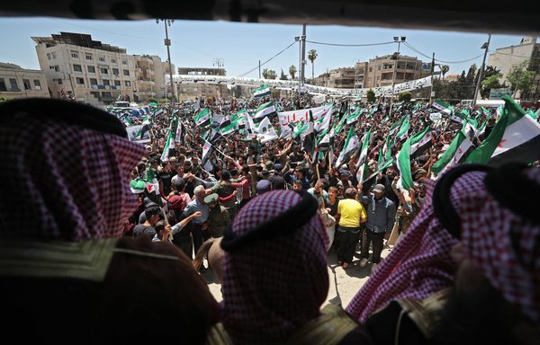 Syrians demonstrate against what they call the illegitimate elections, in the opposition held city of Idlib on May 26, as voting began across Syria for an election guaranteed to return Bashar al-Assad for a fourth term in office. [Omar Haj Kadour/AFP]