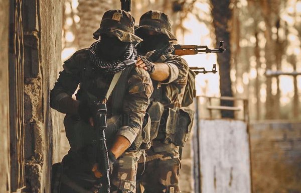 عناصر من ميليشيا كتائب حزب الله التي تدعمها إيران يقفون لالتقاط صورة دعائية نشرت على موقع الميليشيا على الإنترنت.