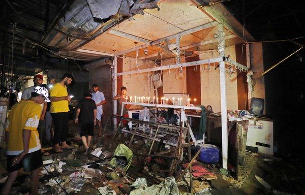 Iraqis light candles at the site of a suicide attack claimed by ISIS in a popular market in Baghdad's Sadr City on July 19. An explosion tore through the market, killing at least 36 and wounding more than 60. [Ahmad al-Rubaye/AFP]