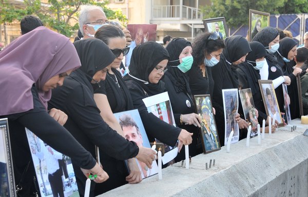 خانواده های قربانیان انفجار ۱۴ مرداد ۱۳۹۹، در بندر بیروت روز ۱۳ تیر ماه در جریان یک مراسم یادبود شمع روشن می کنند. [زیاد حاتم]