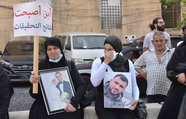 نساء يرفعن صور أبنائهن وأفراد عائلاتهن الذين لقوا حتفهم في انفجار مرفأ بيروت خلال وقفة احتجاجية بتاريخ 4 تموز/يوليو. [زياد حاتم]