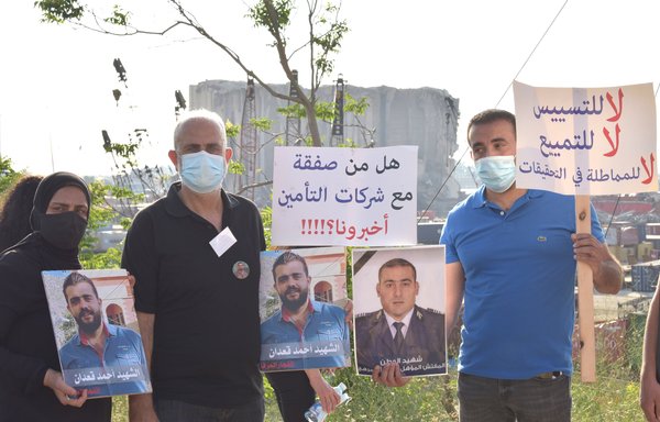 اعضای خانواده های قربانیان انفجار بندر بیروت در روز ۱۳ تیر ماه در جریان یک مراسم یادبود عکس های عزیزانشان را در دست دارند. [زیاد حاتم]