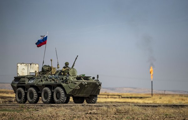A Russian army vehicle drives past an oil field near al-Qahtaniyah in Syria's northeastern Hasakeh province last October. [Delil Souleiman/AFP]