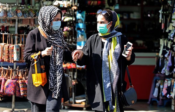 ایرانیان در خیابانی در تهران، پایتخت، در روز ۱۶ تیر. [عطا کناره/خبرگزاری فرانسه]