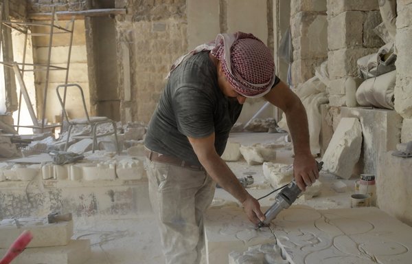 عامل يقوم بترميم منزل بيت غزالة يوم 25 تموز/يوليو الماضي، وهو مبنى من العهد العثماني شيد في منطقة الجديدة ببلدة حلب القديمة شمالي سوريا ويجري حاليا ترميمه. [وكالة الصحافة الفرنسية]