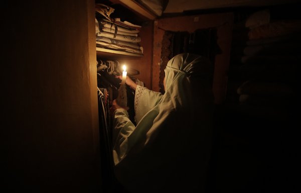 در بیروت ١٩ تیر و با توجه قطع شدید برق در این کشور بحران‌زده، یک زن لبنانی از نور شمع برای کنار گذاشتن لباس‌ها استفاده می‌کند. [انور عمرو/خبرگزاری فرانسه]