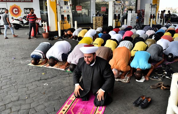 A Sunni Muslim cleric guides Friday prayers, held in a petrol station south of Beirut, on September 3, amid ongoing socioeconomic and political crises that many partly blame on Hizbullah. [AFP]