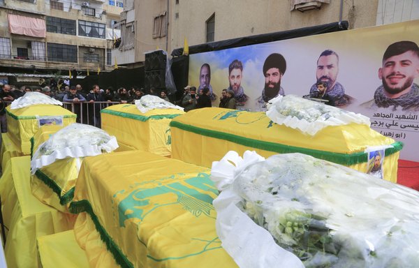 Supporters of Lebanon's Hizbullah gather around coffins of Hizbullah militants killed in Syria during their funeral procession in a suburb of Beirut on March 1, 2020. [AFP]