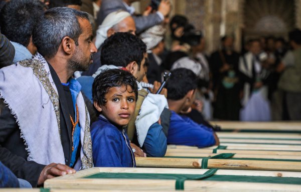 مشيعون يمنيون يجلسون بالقرب من النعوش في مسجد خلال مراسم تشييع بمدينة صنعاء الخاضعة للحوثيين في 14 آذار/مارس 2019. [محمد حويس/وكالة الصحافة الفرنسية]