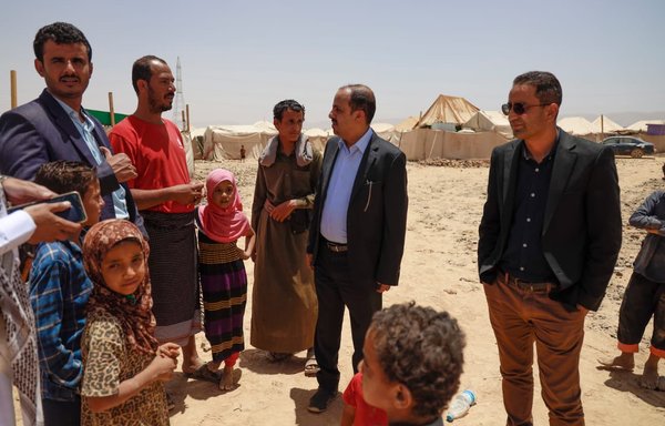 وزير الإعلام اليمني معمر الأرياني (في الوسط) يزور مخيم السويداء للنازحين في محافظة مأرب بتاريخ 12 نيسان/أبريل. [الوحدة التنفيذية لإدارة مخيمات النازحين]