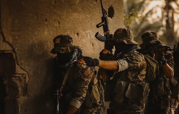 صورة دعائية نشرها على الإنترنت أحد عناصر كتائب حزب الله يظهر فيها عناصر من الميليشيات العراقية المدعومة من إيران وهم يلوحون بأسلحتهم.