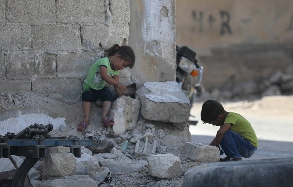 أطفال سوريون يلعبون وسط ركام الأبنية التي دمرت خلال الحرب في بلدة مورك في ريف حماة الشمالي. [عمر حاج كدور/وكالة الصحافة الفرنسية]