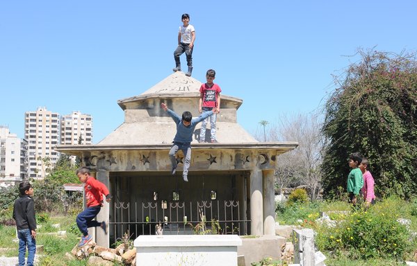 أطفال سوريون في سن الدراسة يلعبون في مقبرة بأحد أحياء طرابلس في خريف العام 2021 بدل الالتحاق بالمدرسة. [زياد حاتم]