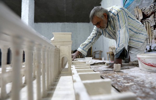 علی صالح ۵۸ ساله، ساکن سابق پالمیرا، روز ۲۵ دی در کارگاهی در الباب در شمال سوریه، با استناد به حافظه خود از یک مکان مهم باستان شناسی که توسط داعش به شدت آسیب دیده بود، مدلی از چوب و گچ می سازد. [بکر القاسم/ خبرگزاری فرانسه]