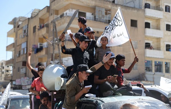 اعضای اتحاد هیئت تحریر الشام ۲۹ مرداد با پرچم خود و پرچم طالبان در شهر ادلب رژه می‌روند. [عمر حاج قدور/خبرگزاری فرانسه]