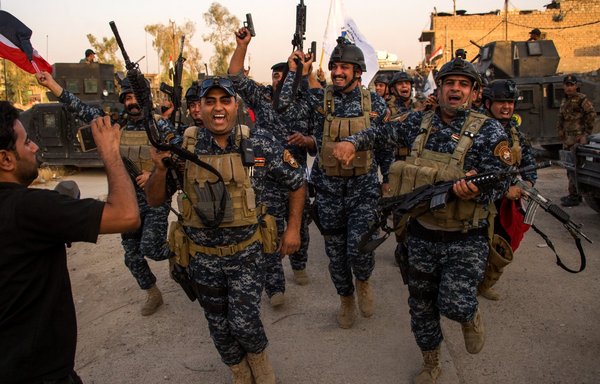 عناصر من القوات العراقية يحتفلون في مدينة الموصل القديمة في 10 تموز/يوليو 2017، بعد إعلان الحكومة "تحرير" المدينة المحاصرة من داعش. [فاضل سنا/وكالة الصحافة الفرنسية]