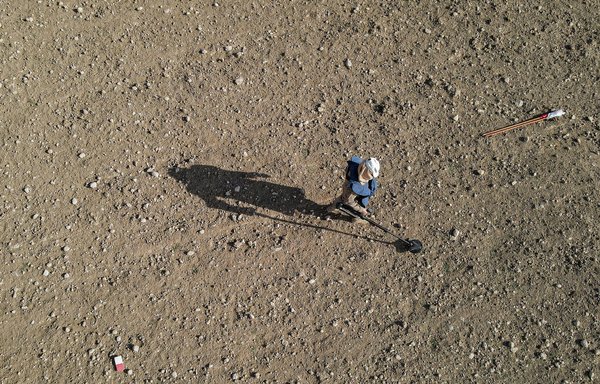 این عکس که در روز ۸ آذر گرفته شده است، نمای هوایی از یک رفتگر را نشان می دهد که در جستجوی مین ها و مهمات منفجرنشده در نزدیکی روستای حسن جلاد، در شمال موصل، از یک فلزیاب استفاده می کند. [زید العبیدی/ خبرگزاری فرانسه]