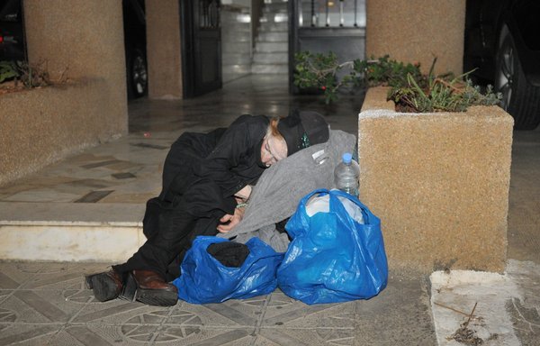 یک زن بی خانمان در ورودی ساختمانی در جیده، منطقه متن، خوابیده است. [زیاد حاتم]