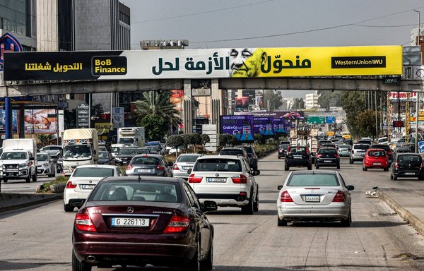 A billboard on December 8 advertises for a wire money transfer agency atop a highway in Beirut. Instead of the usual building-sized billboards advertising champagne and jewellery before Christmas, this year's billboards tell a different, more frugal story: one that reflects the worst financial crisis to ever hit the once free-spending Middle Eastern country. [Joseph Eid/AFP]