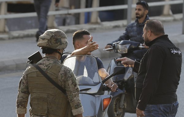 Lebanese security forces, including intelligence agents (R) stop motorcyclists on a main road during clashes in the centre of Beirut on October 29, 2019. [Joseph Eid/AFP]