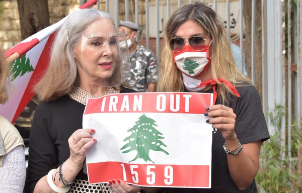 سيدتان تحملان لافتة معارضة لإيران خلال تظاهرة أمام قصر العدل بتاريخ 13 تشرين الأول/أكتوبر. [زياد حاتم/المشارق]