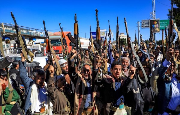 Armed Yemeni supporters of the Iran-backed Houthis brandish their weapons as they rally in Sanaa on January 27. [Mohammed Huwais/AFP]