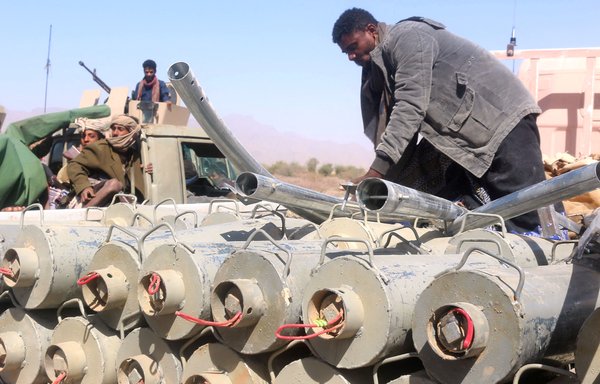 Yemeni pro-government fighters surround ordnance removed from the district of Harib on January 25, after the Houthis were expelled from the district by UAE-trained Giants Brigade fighters. [Saleh al-Obeidi/AFP]