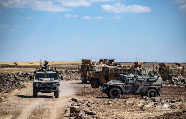 Russian and Turkish military vehicles patrol in the countryside of Rumaylan in al-Hasakeh province, Syria, near the Turkish border, on September 16. [Delil Souleiman/AFP]