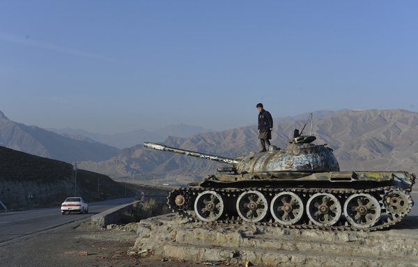 This photo taken on November 28, 2019, shows an Afghan boy playing on the wreckage of a Soviet-era tank on the outskirts of Kabul. December 2019 marked the 40th anniversary of the Soviet Union's invasion of Afghanistan. Defeated Soviet forces withdrew in February 1989. [Noorullah Shirzada/AFP]