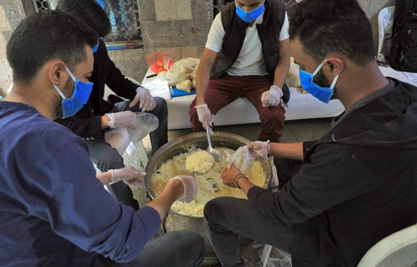 داوطلبان یمنی در روز ۳۰ فروردین کمک های غذایی را برای وعده افطار آماده می کنند تا میان مستمندان و نیازمندان صنعا توزیع شود. [محمد حویس/ خبرگزاری فرانسه]