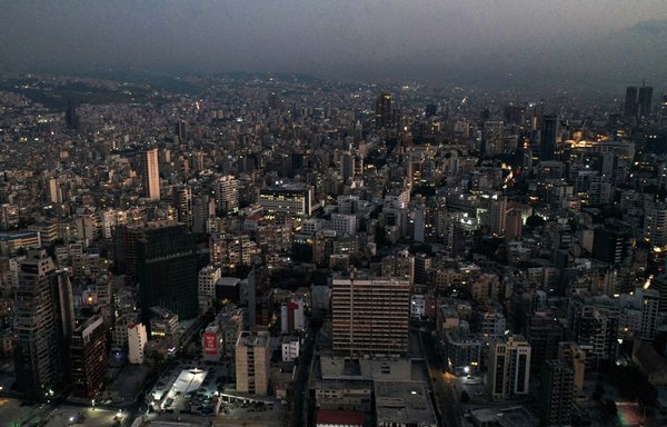 This picture taken on October 11 shows a sunset aerial view of the Electricité du Liban (EDL) building (C) in Beirut, in darkness during a power outage. [AFP]