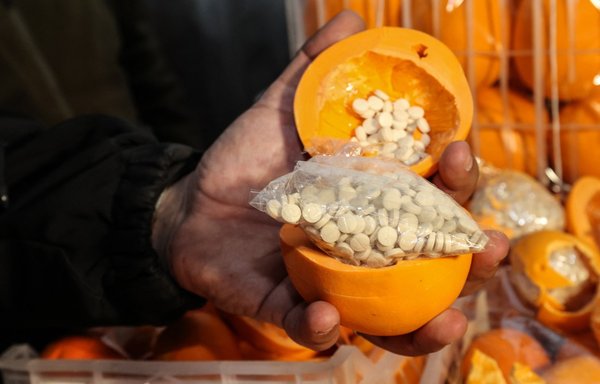 در این عکس آرشیوی که روز ۸ دی‌ماه گرفته شده است، یک مرد تعدادی پرتقال تقلبی را نشان می‌دهد که با قرص‌های کاپتاگون پر شده و در جعبه‌های حاوی میوه واقعی جاسازی شده است. این محموله توسط تیپ گمرک و مبارزه با مواد مخدر بندر بیروت توقیف شده بود. [انور عمرو/خبرگزاری فرانسه]